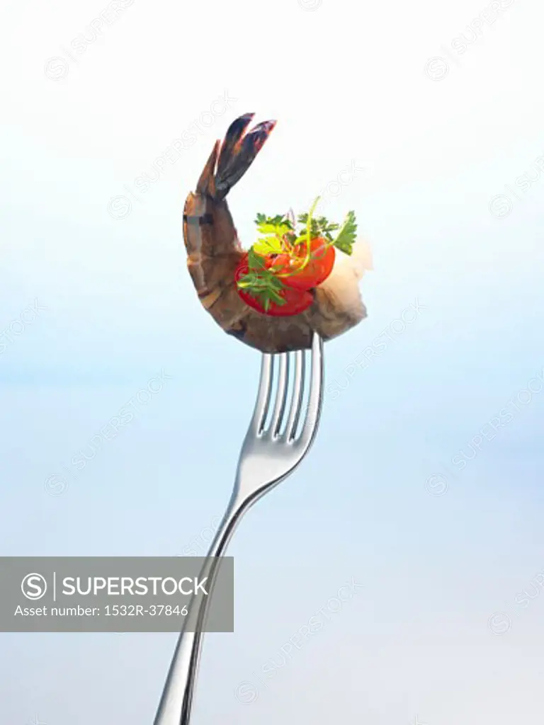 Prawn with parsley and tomato on a fork