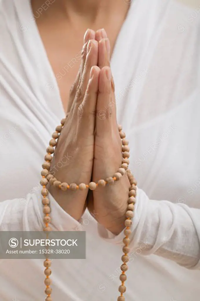 Young woman meditating with hands together