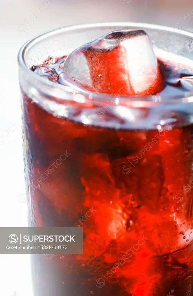 Red fruit juice with ice cubes in a glass