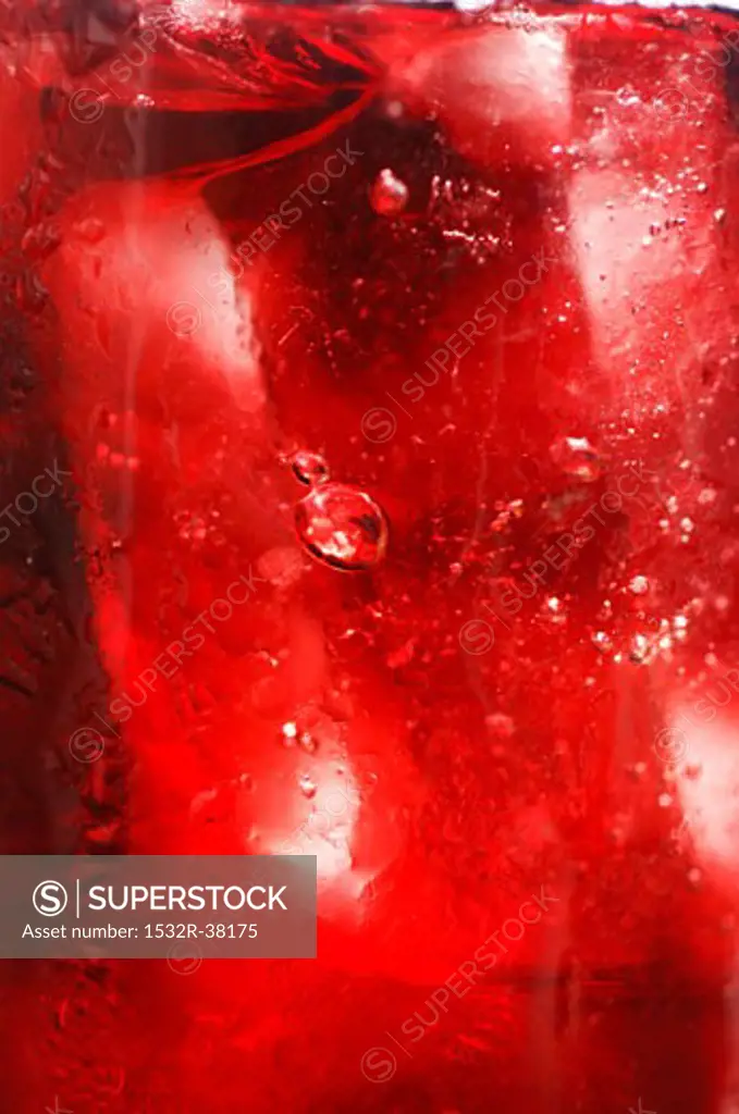 Red fruit juice with ice cubes, full-frame