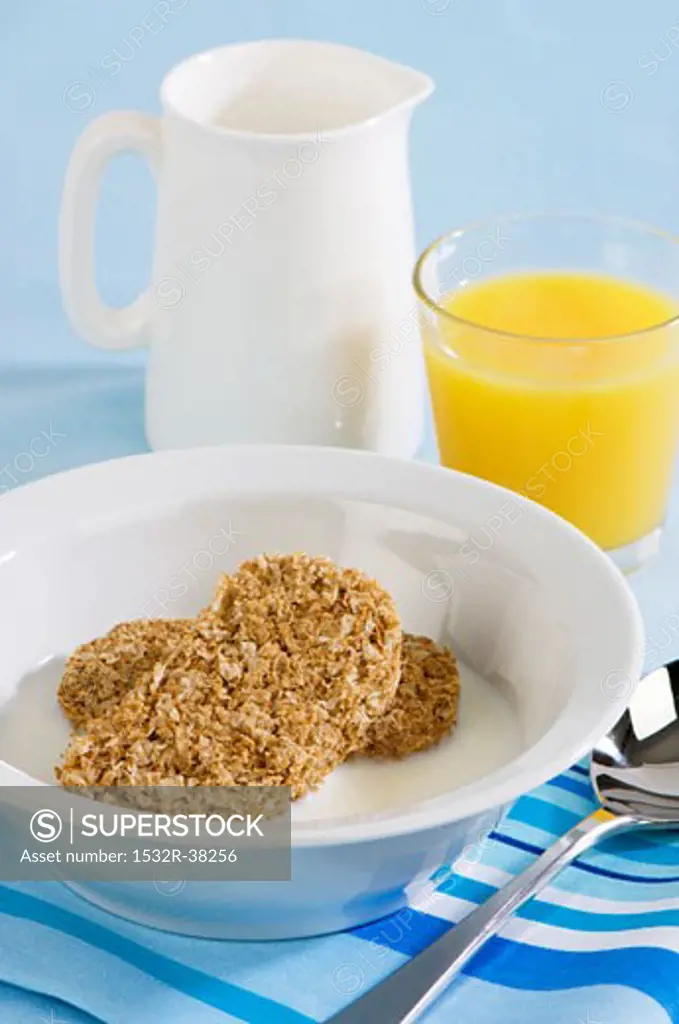 Wheat biscuits with milk and a glass of orange juice