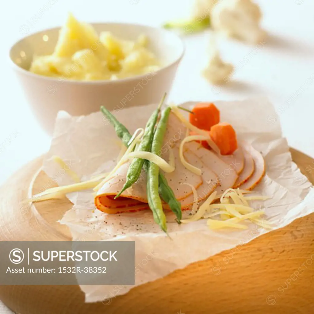 Ham with cheese and vegetables on paper