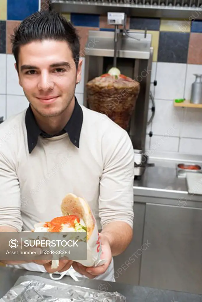 Young chef holding a döner kebab
