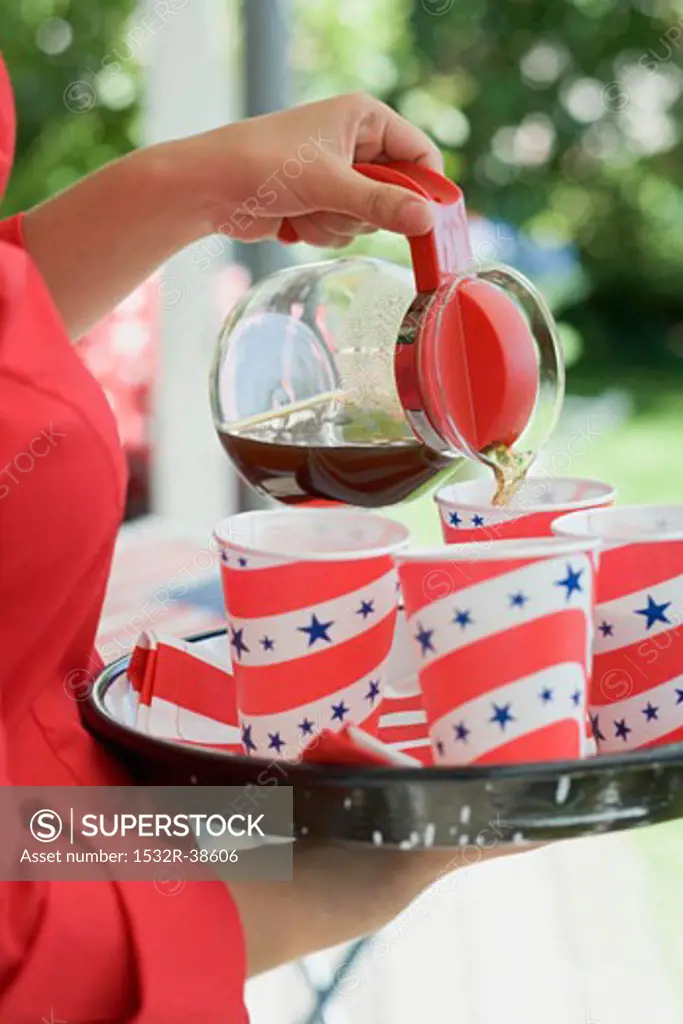Woman pouring coffee into paper cup (4th of July, USA)