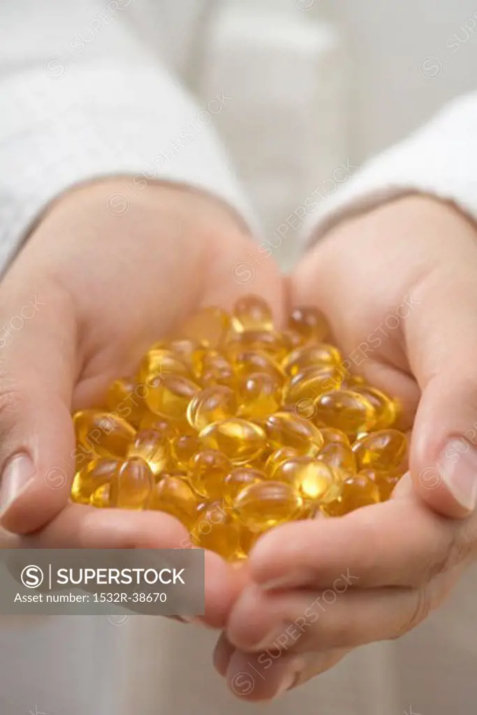 Hands holding vitamin capsules