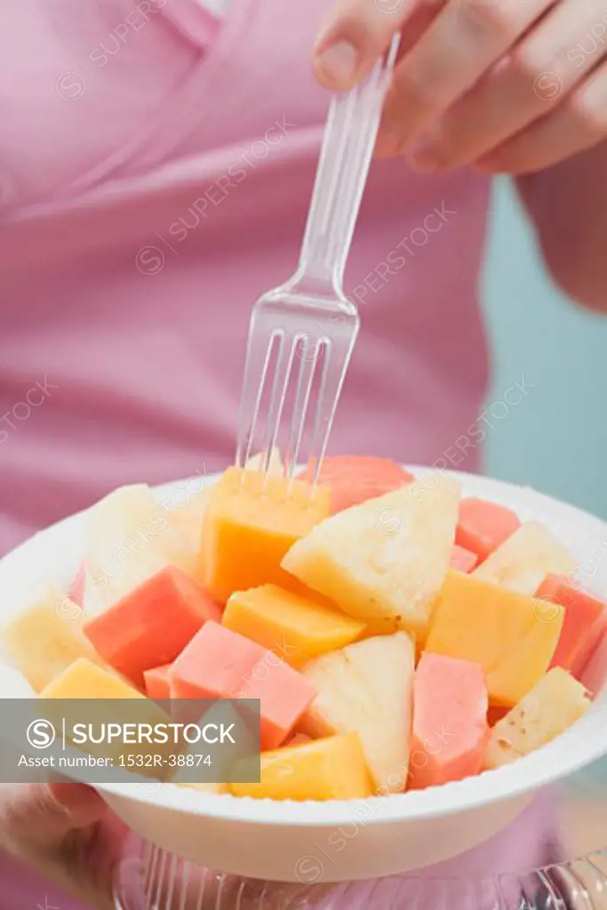 Woman eating exotic fruit salad