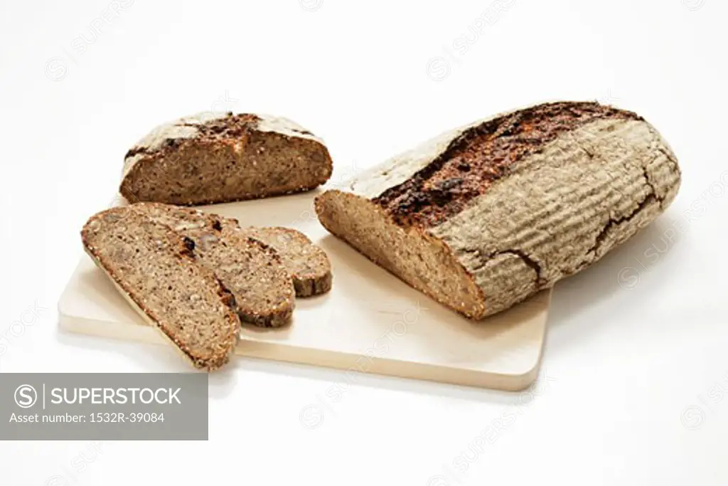 Two different loaves of wood-oven bread, partly sliced