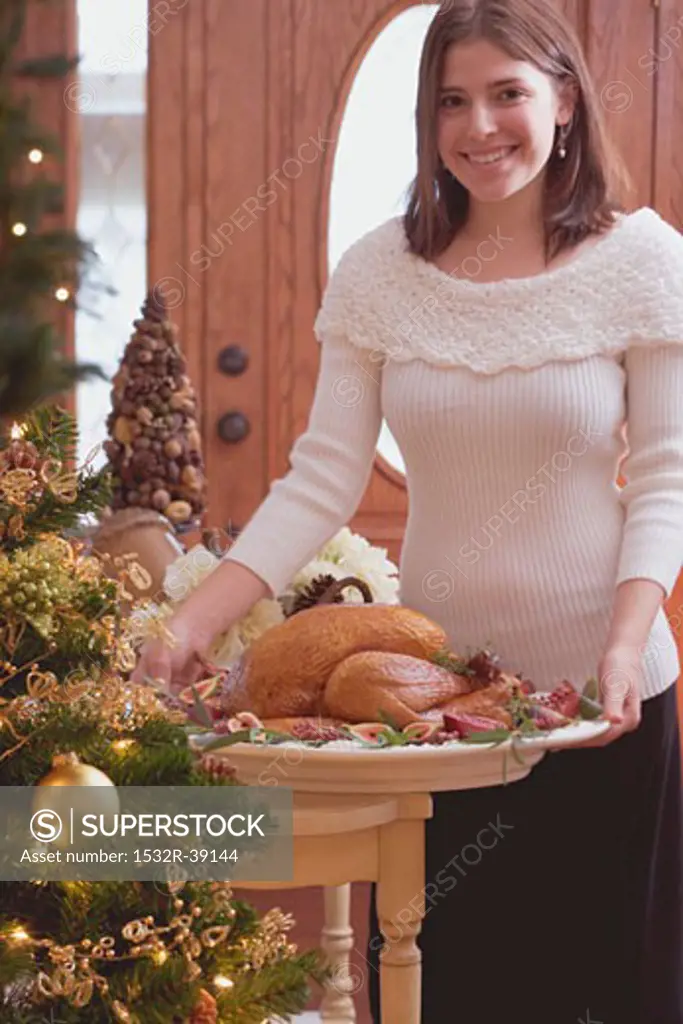 Young woman serving roast turkey (Christmas)