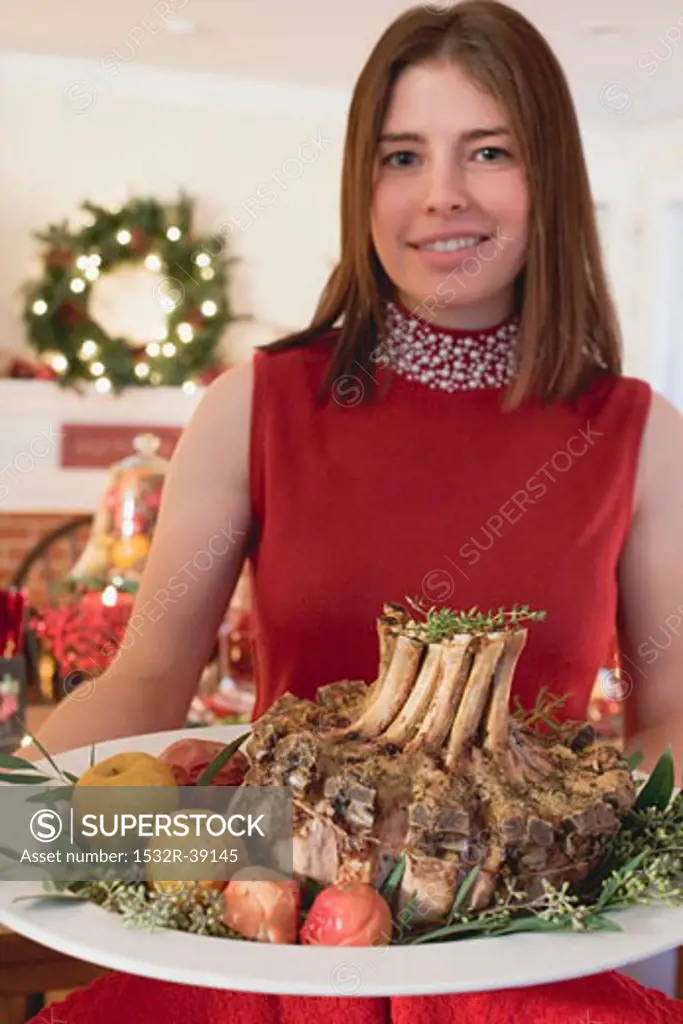 Young woman serving rack of pork (Christmas)