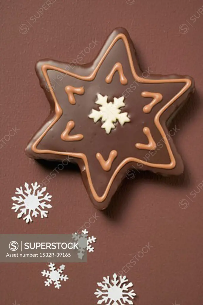 Star biscuit with chocolate icing on brown background