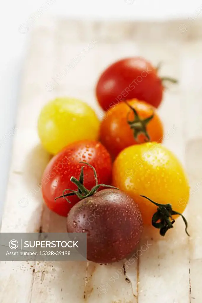 Tomatoes of various colours with drops of water