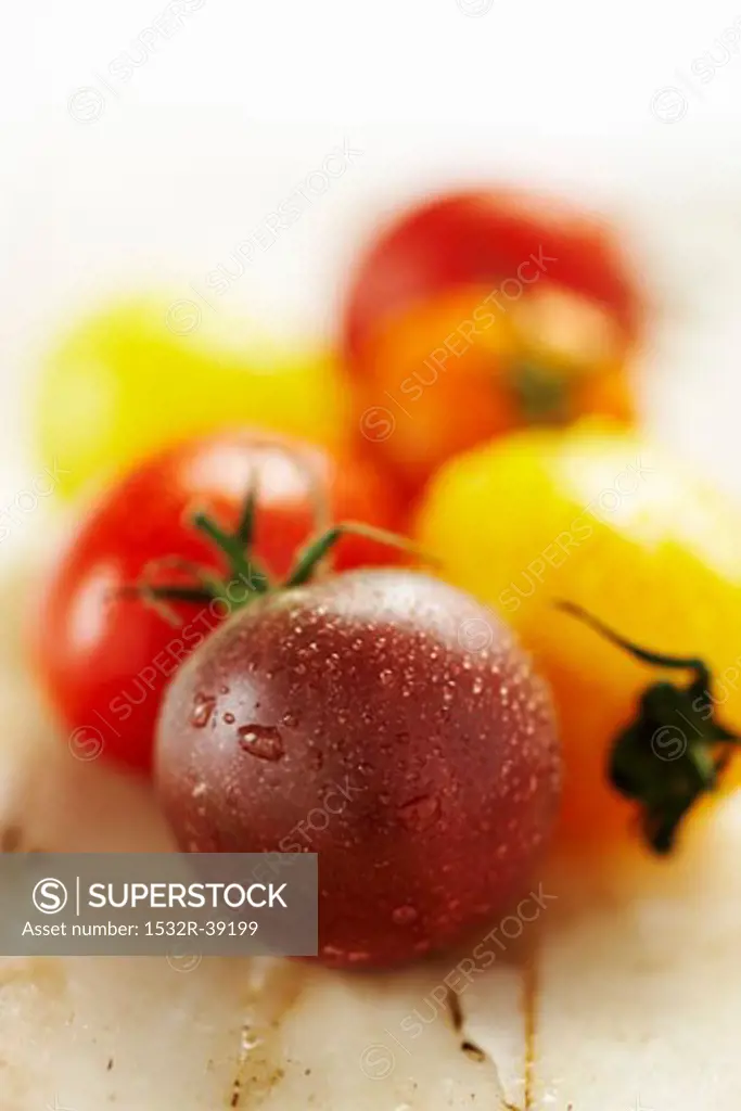 Tomatoes of various colours with drops of water