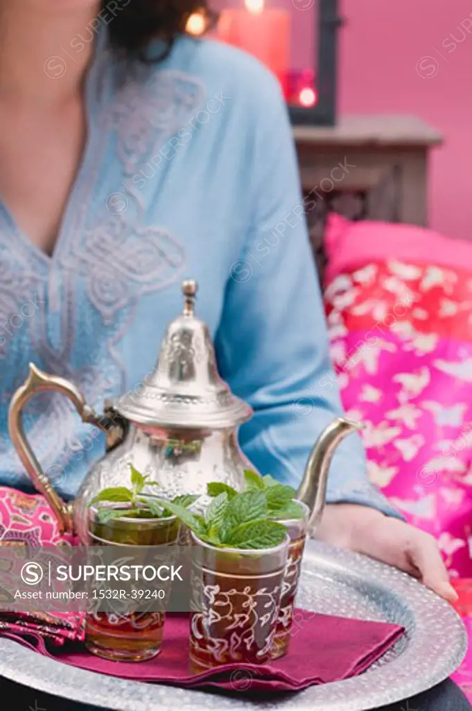 Woman serving peppermint tea on tray
