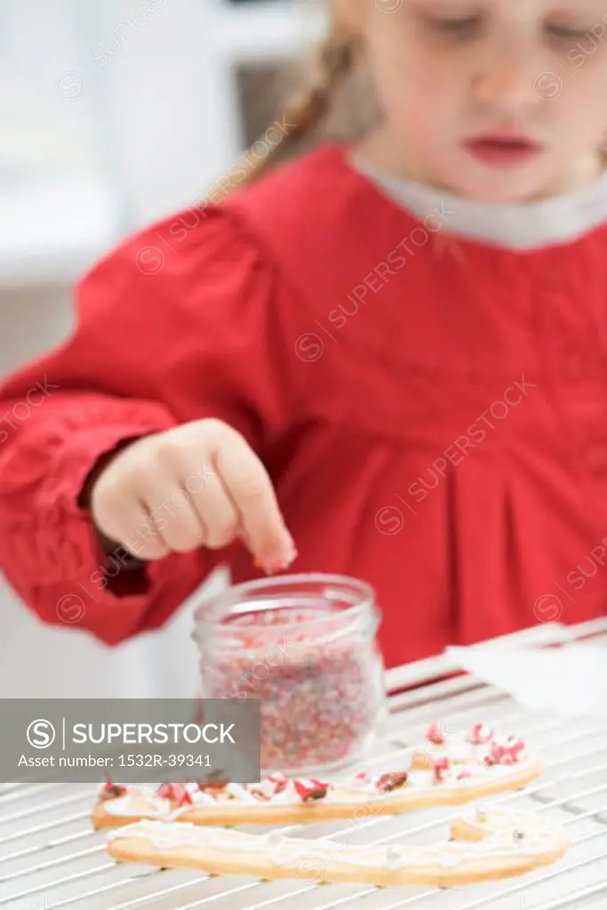 Small girl decorating Christmas biscuits