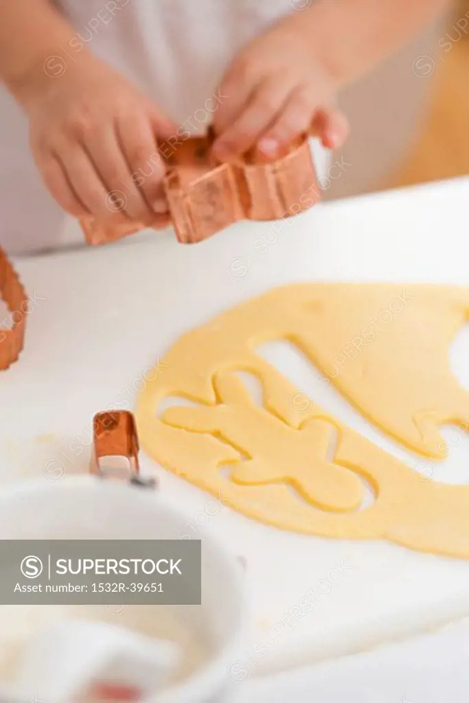 Child cutting out a biscuit