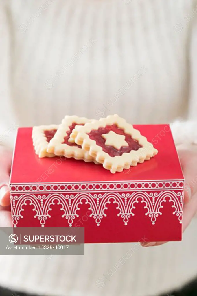 Woman holding jam biscuits on red box