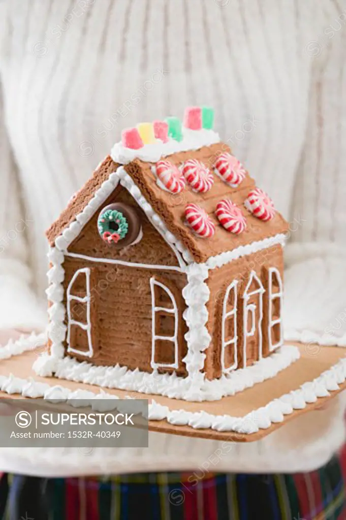 Woman holding gingerbread house