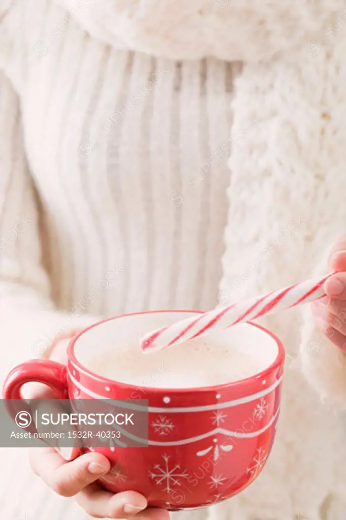 Woman holding cup of cocoa and candy cane (Christmas)
