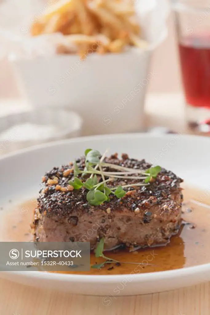 Peppered steak with cress, chips in background