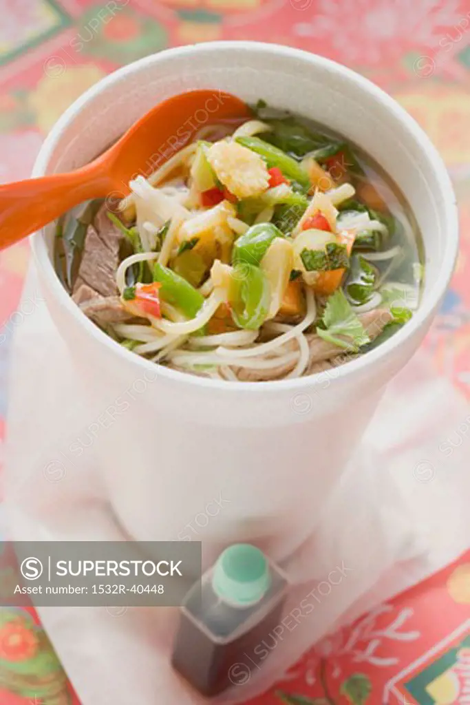 Noodle soup with beef and vegetables in cup, soy sauce