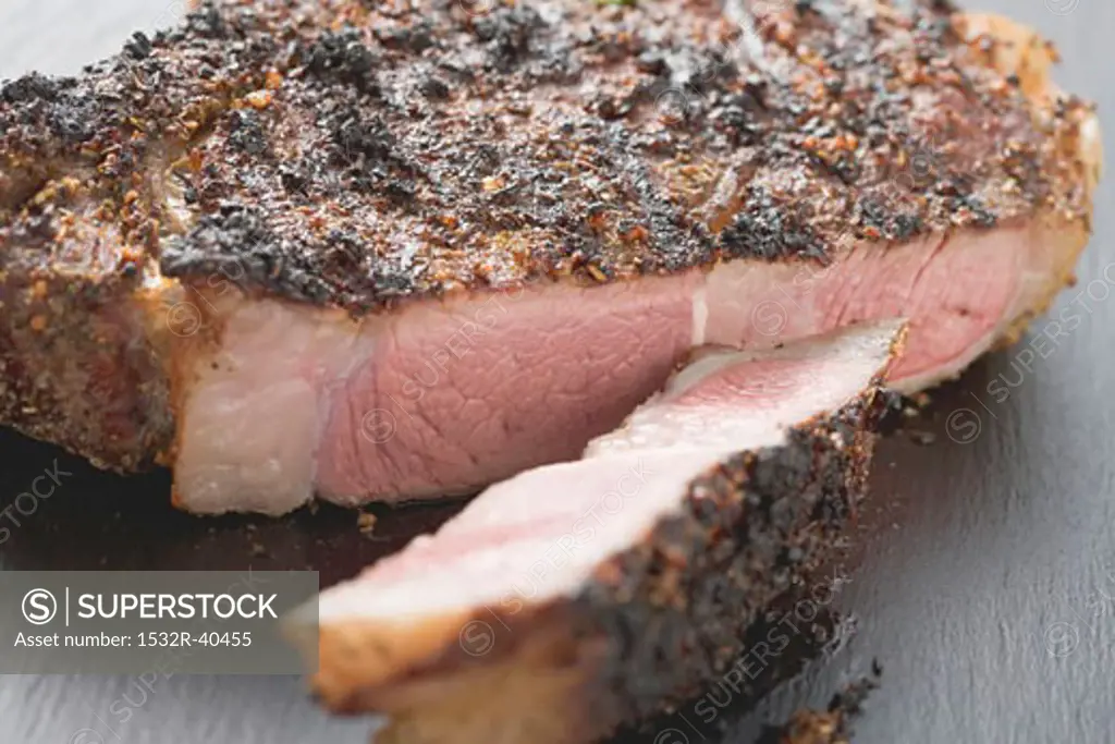 Spicy fried rib eye steak, a slice cut off