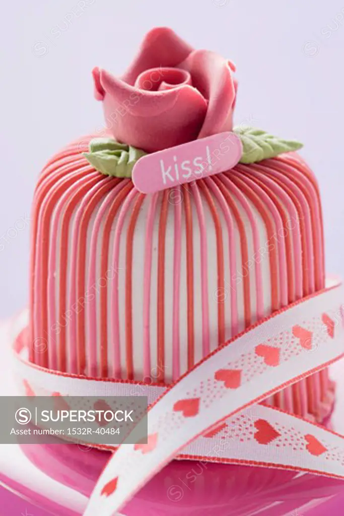 Marzipan-covered cake with ribbon on pink chocolate box