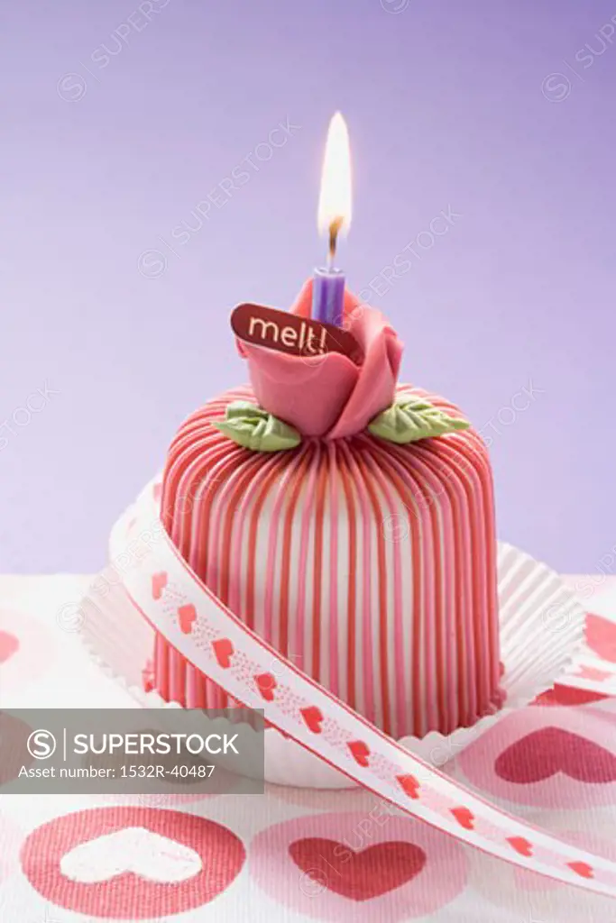 Marzipan-covered cake with candle and ribbon