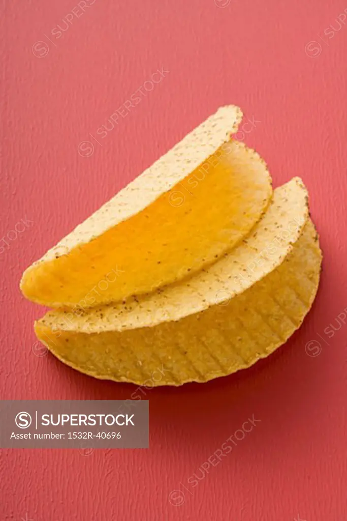 Two taco shells on red background