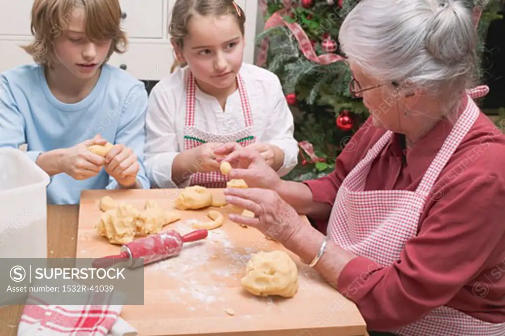Grandmother telling grandchildren how to shape vanilla crescents