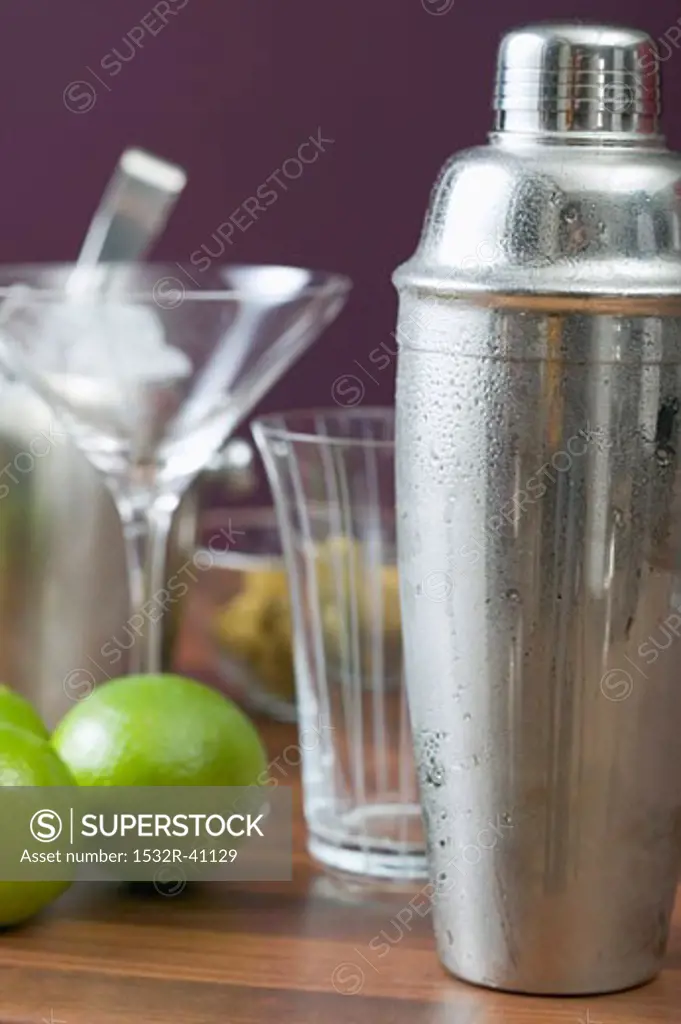 Cocktail shaker, glasses and limes