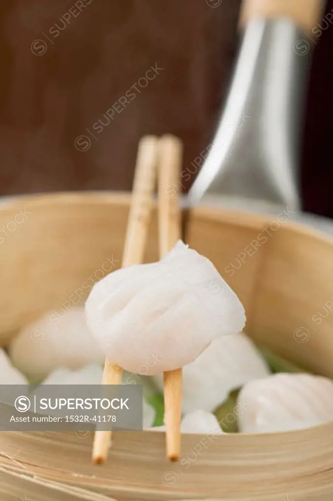 Dim sum on chopsticks and in bamboo steamer