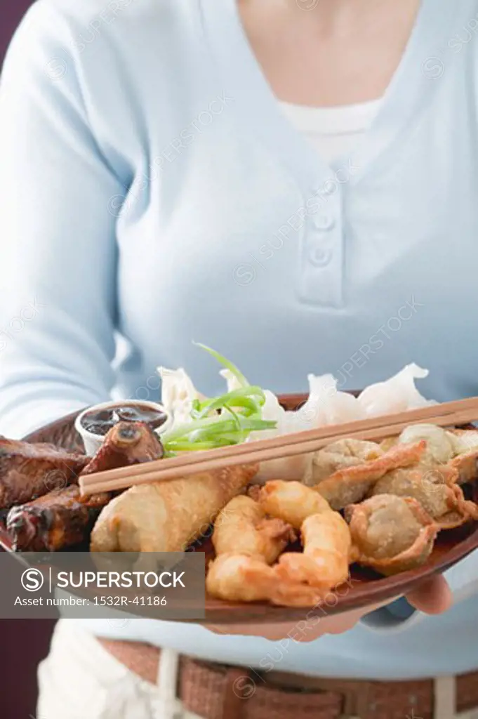 Woman holding Asian appetiser platter