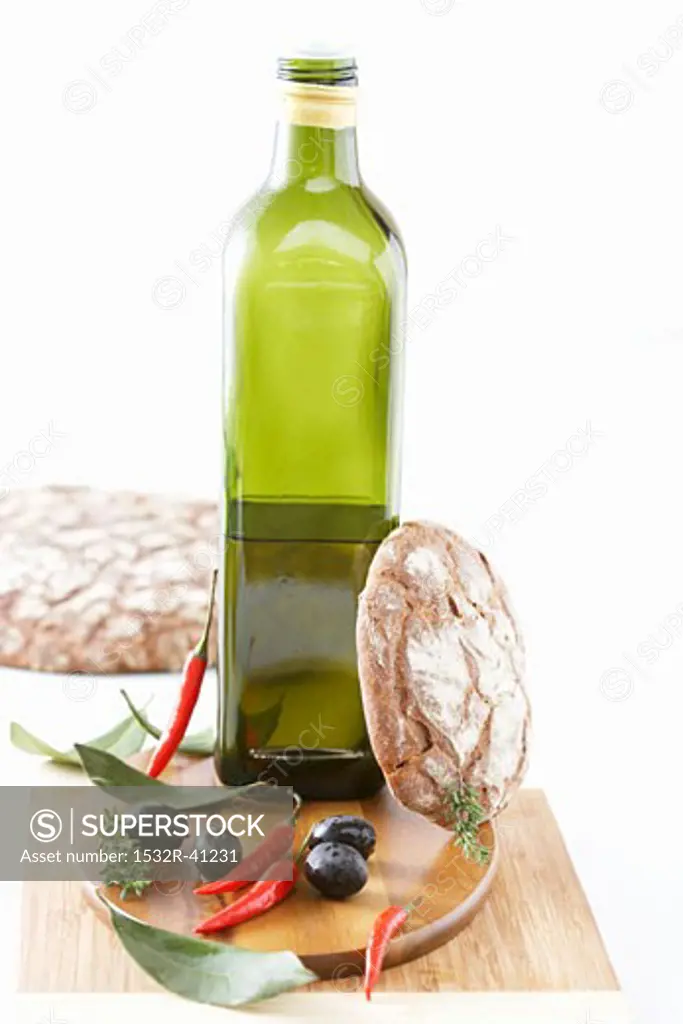 Bottle of olive oil, olives, chillies and rustic bread