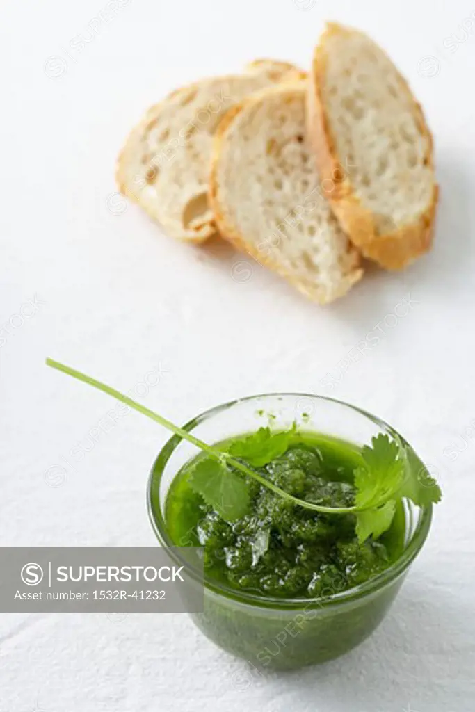 Green mojo sauce in glass basin, slices of white bread