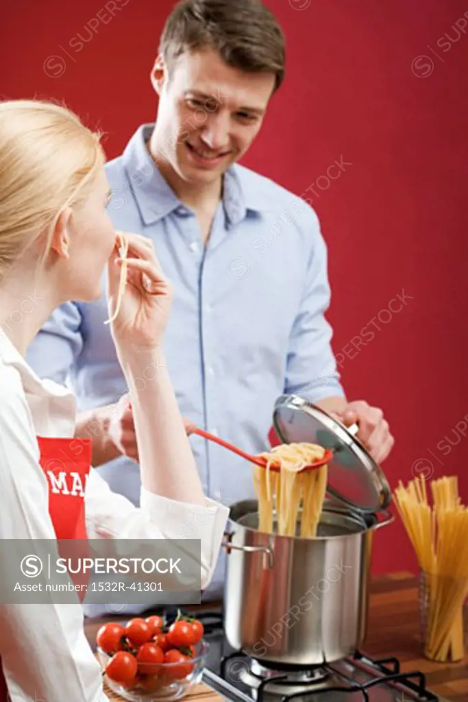 Woman tasting cooked spaghetti