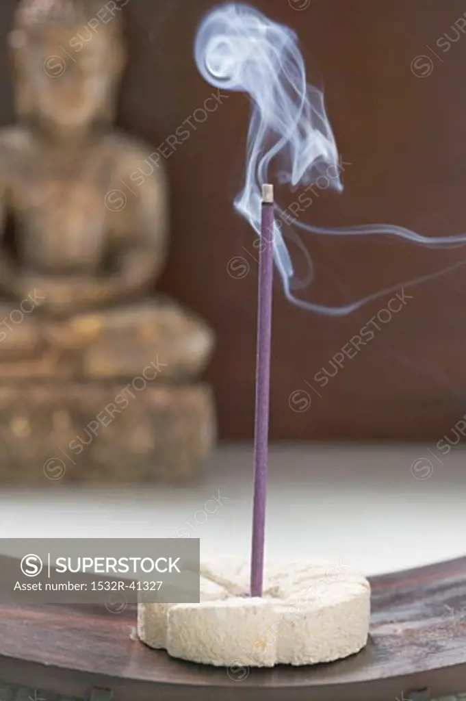 Incense stick in front of Buddha statue