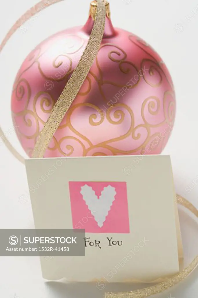 Pink Christmas bauble with gold ribbon and card