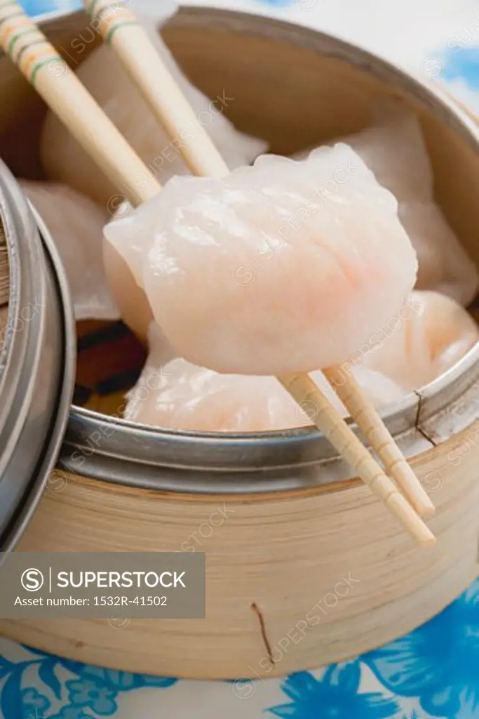 Dim sum in bamboo steamer and on chopsticks (Asia)