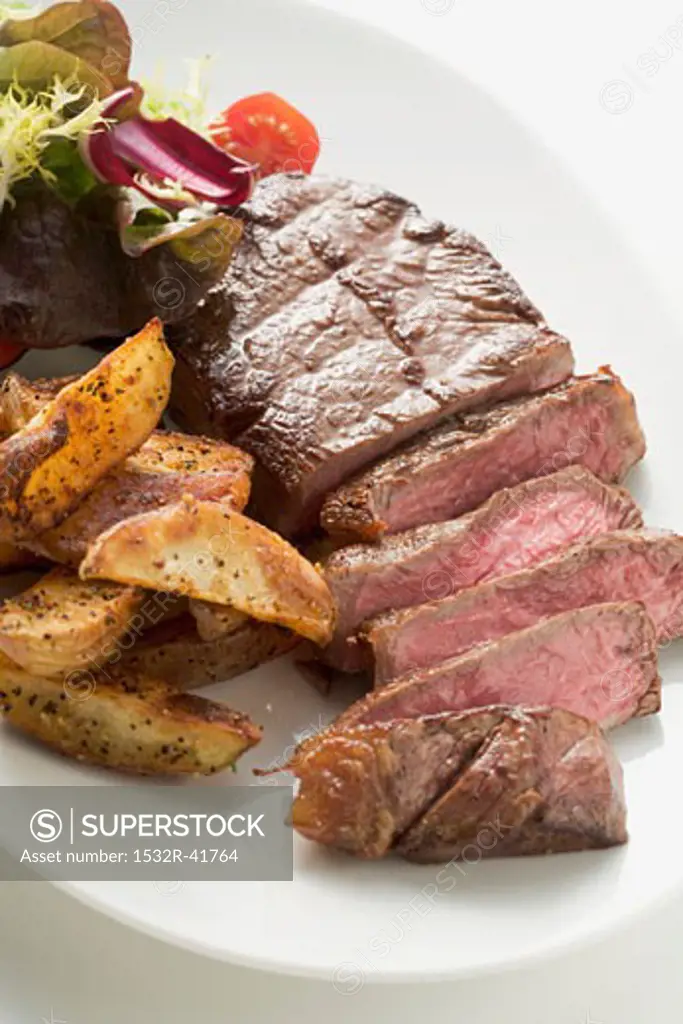 Beef steak with potato wedges and salad