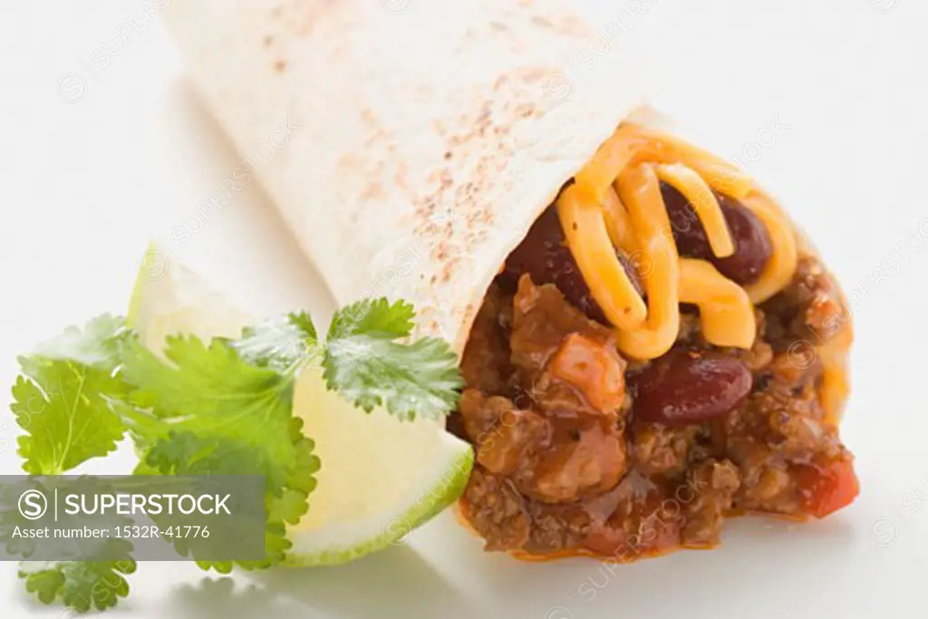 Burrito with chili con carne and cheese, lime, coriander