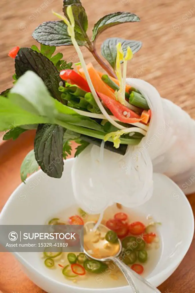 Rice paper roll filled with vegetables, noodles & herbs, chilli sauce