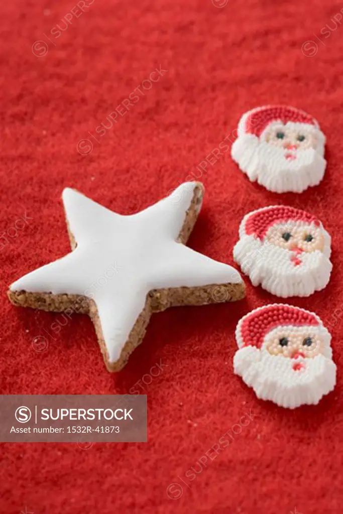 Cinnamon star and Father Christmases on red felt
