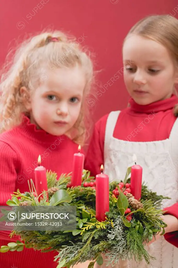Two small girls holding Advent wreath