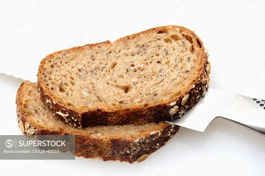 Two slices of multigrain bread with bread knife