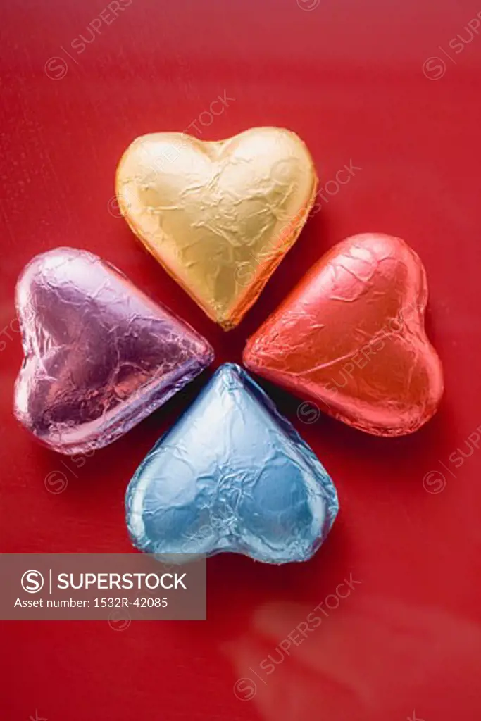 Four heart-shaped chocolates in foil