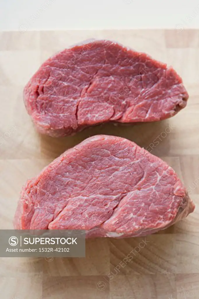 Two beef medallions on chopping board