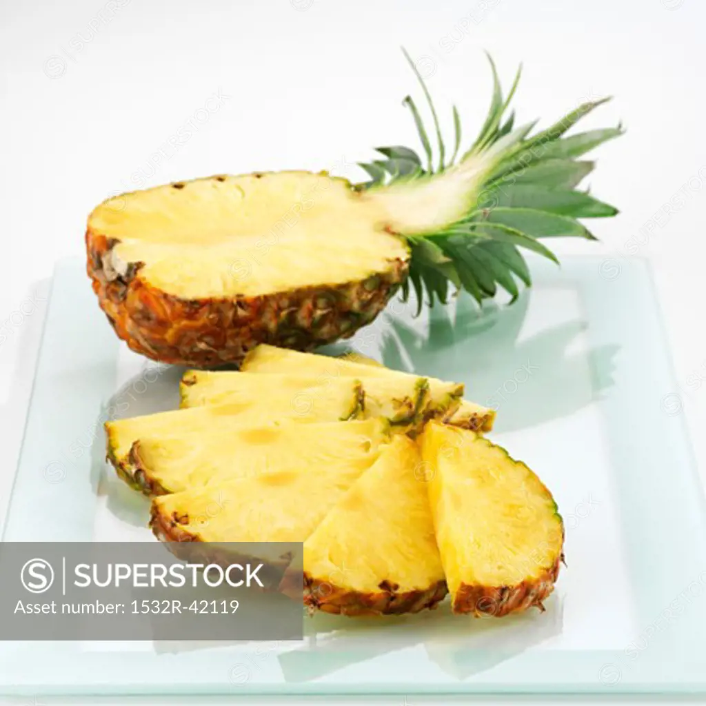 Half a pineapple and pineapple slices