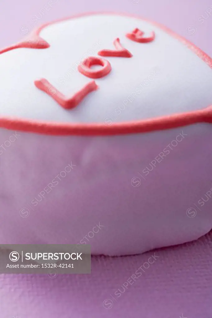 Pink heart-shaped cake with the word Love