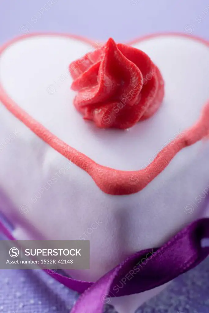 Pink heart-shaped cake with ribbon