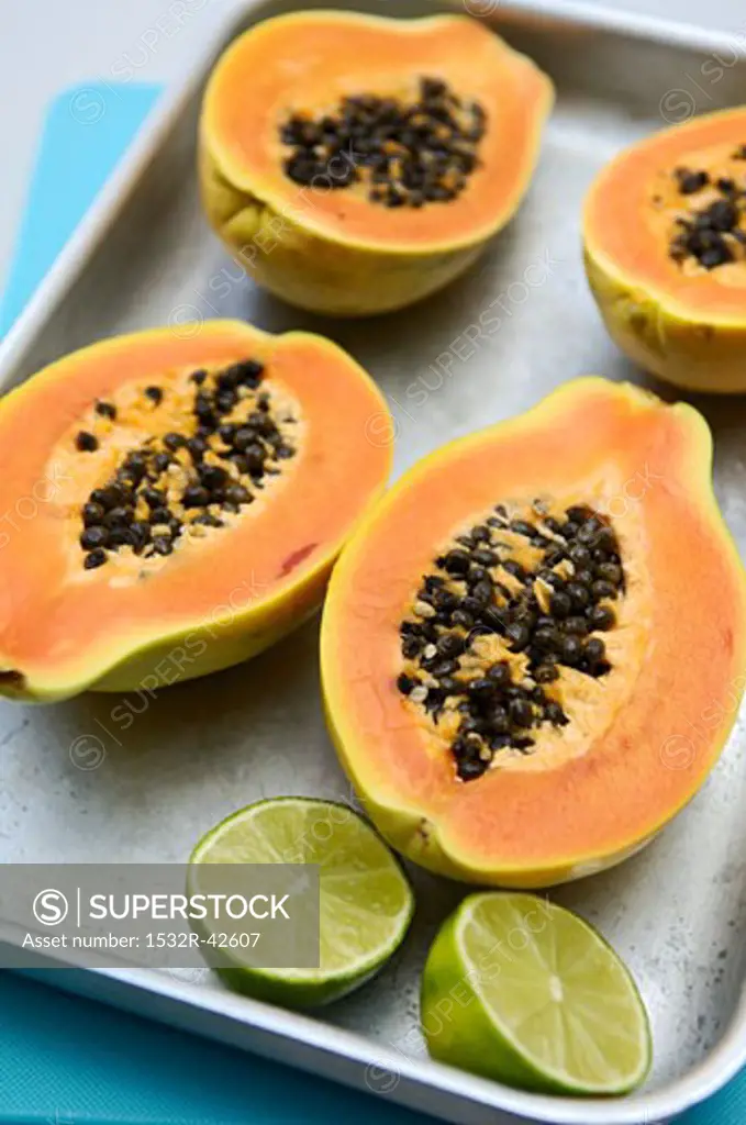 Halved papayas and lime
